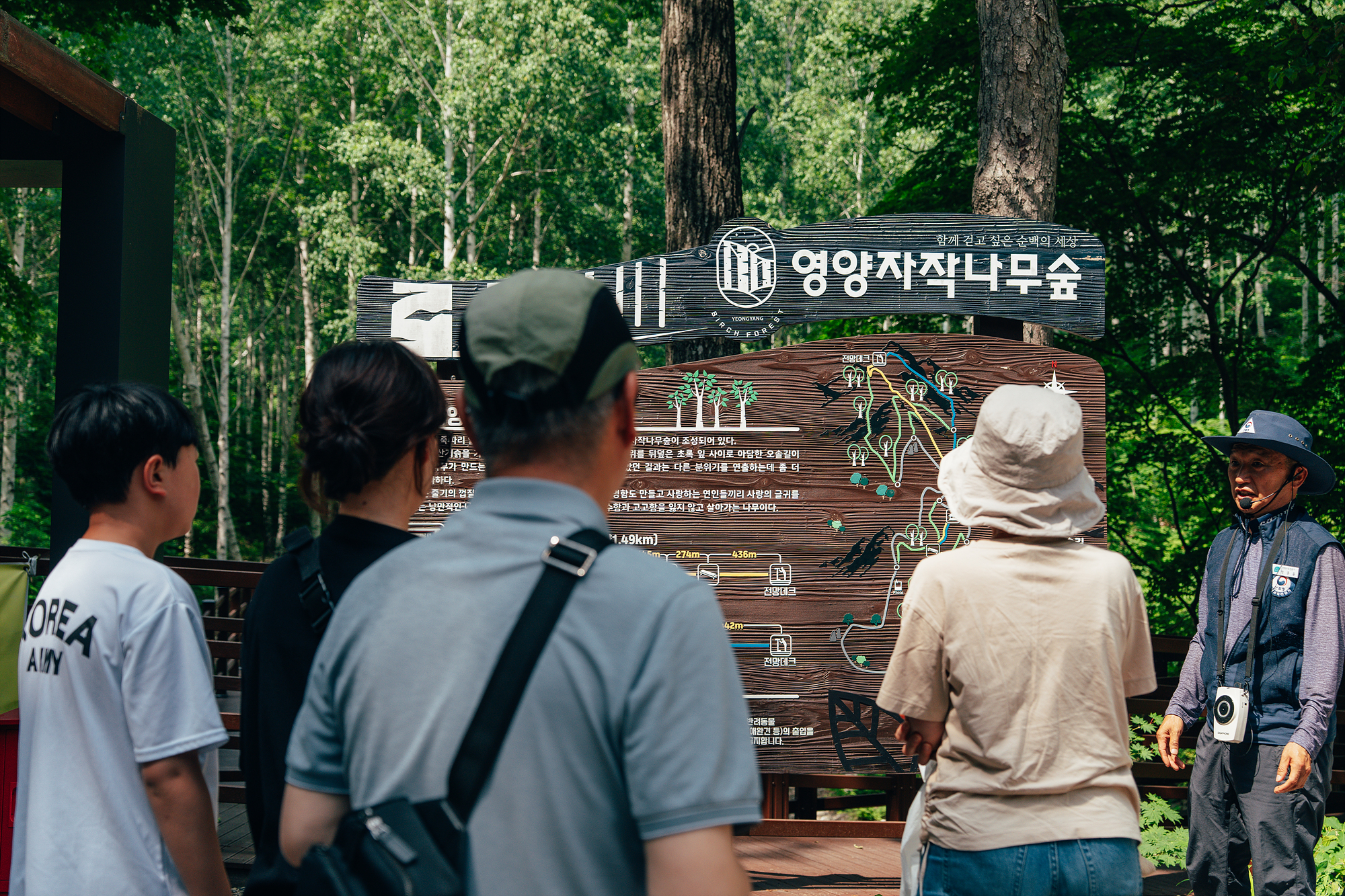 영양 자작나무숲 입구 안내판 앞에서 해설사가 간단한 설명을 하고 있습니다.