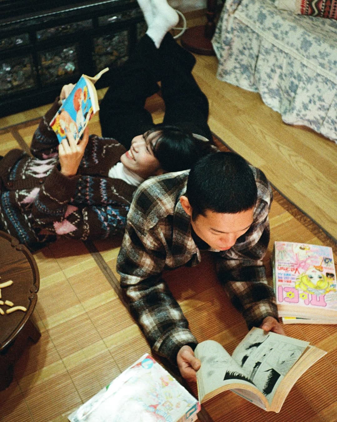 펜탁스17 PENTAX17로 촬영한 커플 스냅. 커플이 바닥에 엎드려 만화책을 보고 있다.