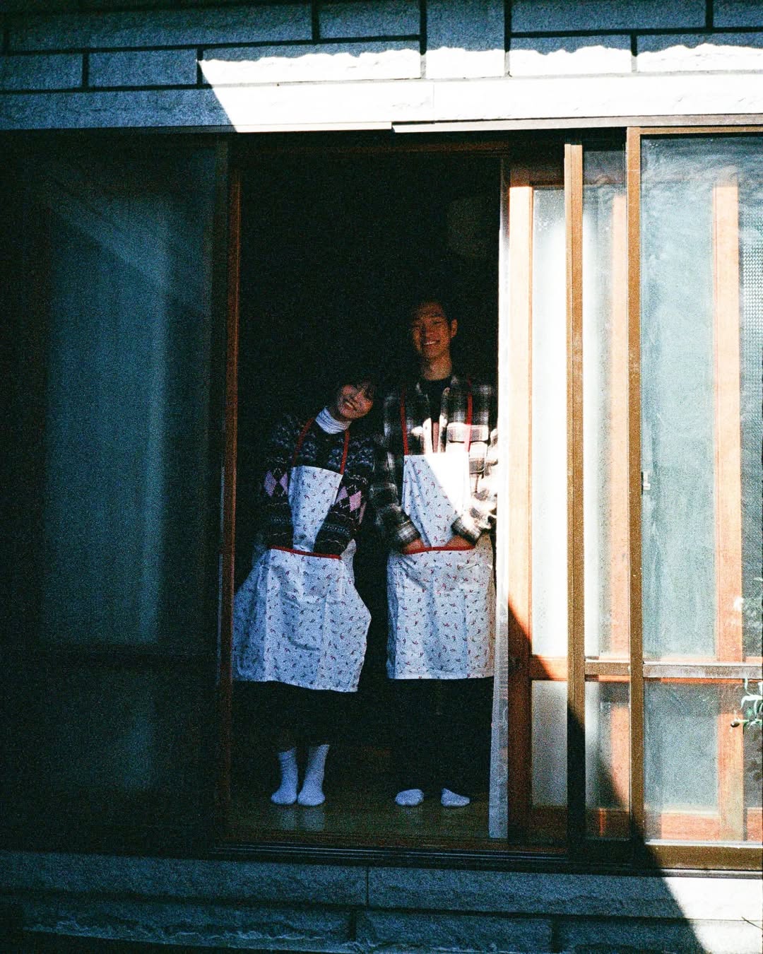 펜탁스17 PENTAX17로 촬영한 커플 스냅. 앞치마를 두른 커플이 카메라를 향해 웃고 있다.